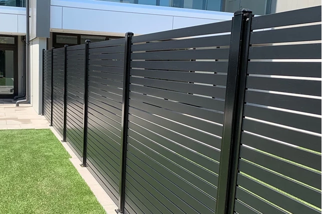 Antracit színű alumínium lamellás kerítés részlete.