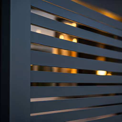 Antracit matt lemezkerítés függőleges C profilú lécekkel modern családi ház előtt.